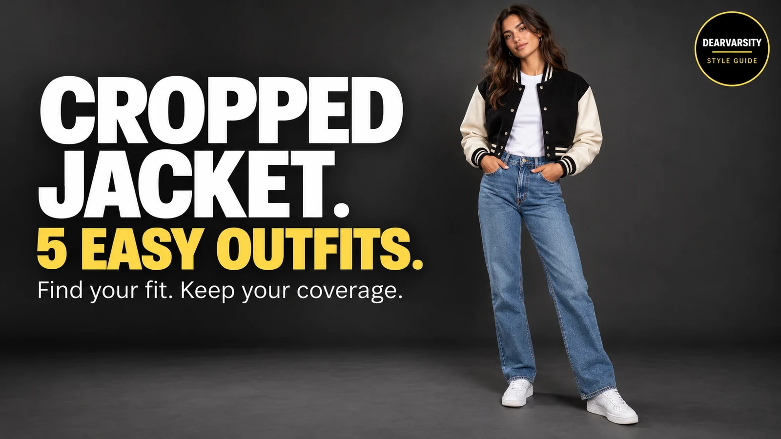 Woman styling a black-and-cream cropped varsity jacket with a white tee, blue jeans and white sneakers